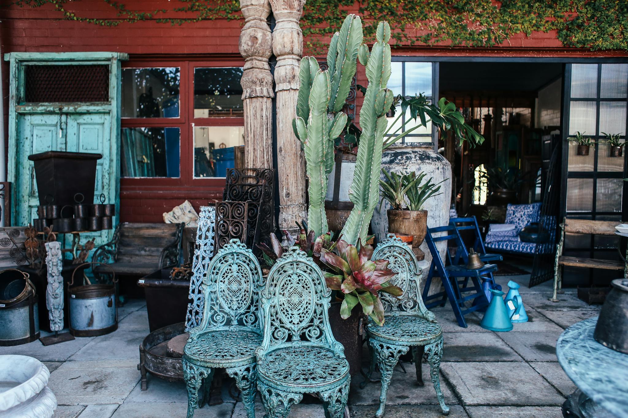 Eclectic vintage patio scene with retro furniture, plants, and unique decor items.